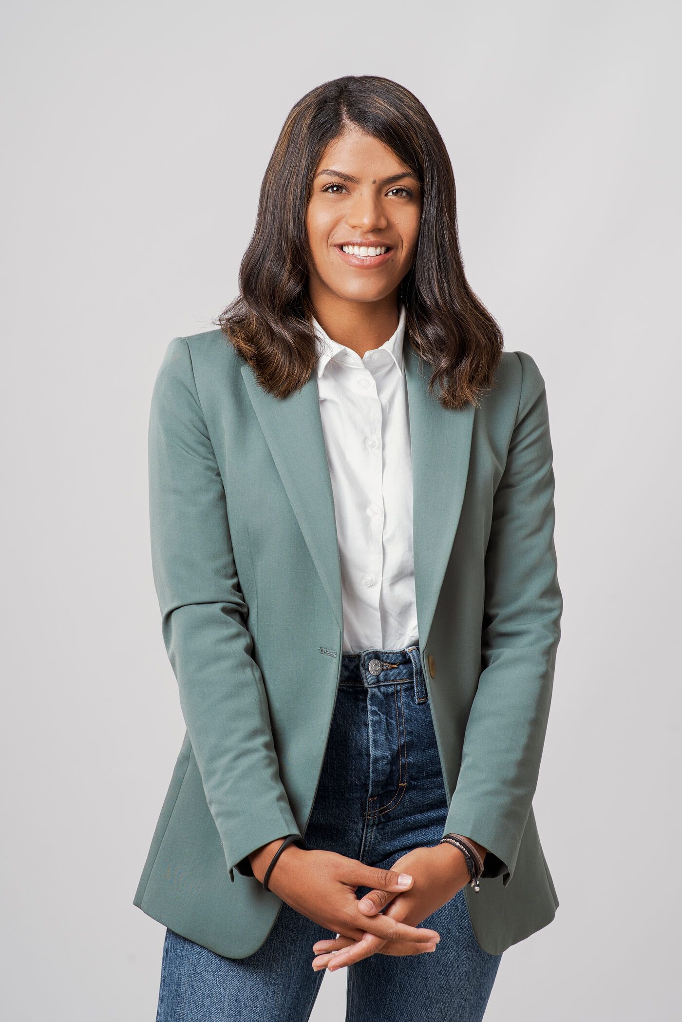 Zoraimy Sánchez, psicóloga de pareja, de pie y sonriendo con americana verde