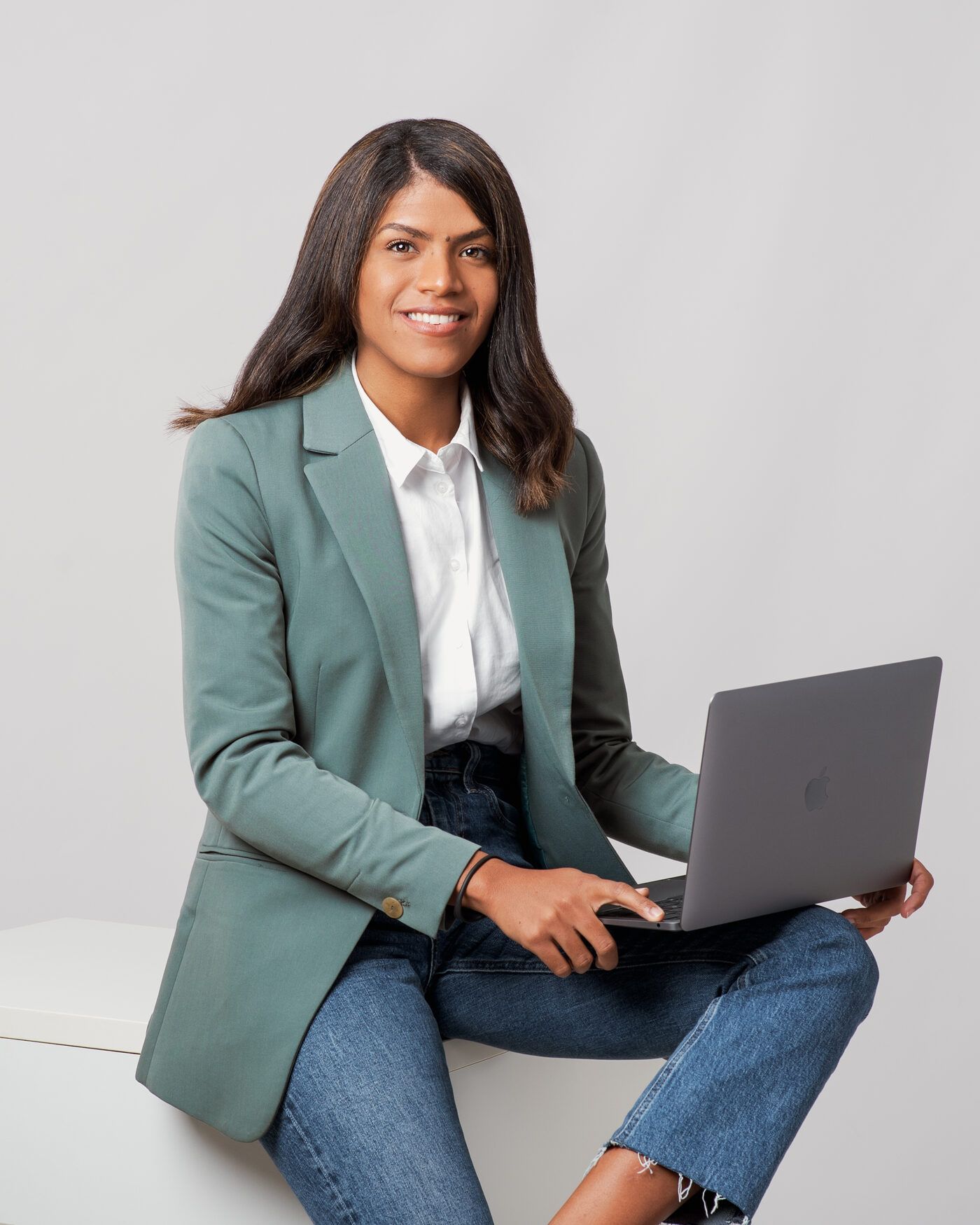Zoraimy Sánchez sentada con un portátil, sonriendo